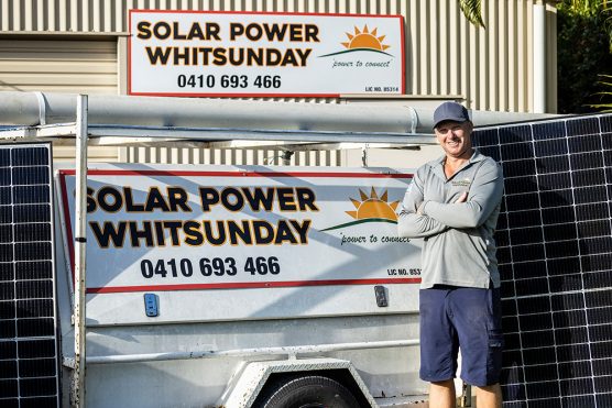 Man standing in front of Solar Power Whitsunday sign — Solar Power Systems in Proserpine, QLD
