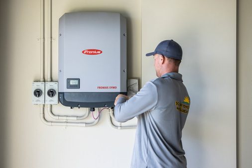 Man installing solar panel box — Solar Power Systems in Proserpine, QLD