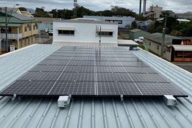 View across the town with a rooftop solar panel array in the foreground — Solar Power Systems in Whitsundays QLD