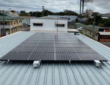 View across the town with a rooftop solar panel array in the foreground — Solar Power Systems in Whitsundays QLD