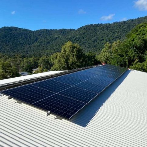 Mountain Range Seen Beyond a Tin Roof With Solar Panels — Solar Power Systems in Proserpine, QLD